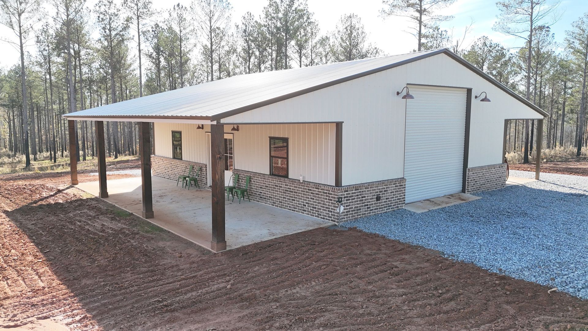 A white building with a covered porch and trees in the background