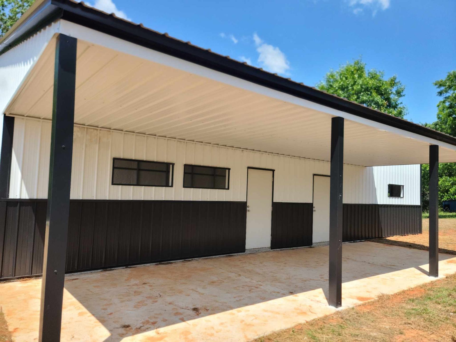 A white and black building with a covered porch.