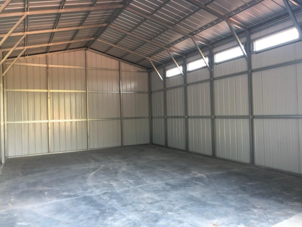 A large empty warehouse with a concrete floor and a metal roof.