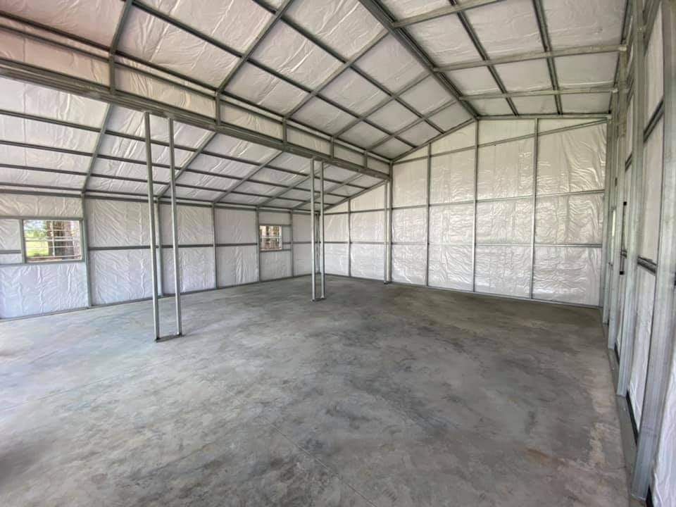 A large empty building with a concrete floor and a roof.