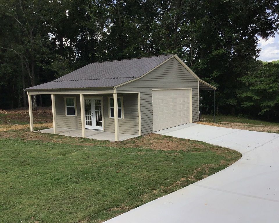 A small house with a garage attached to it and a porch.