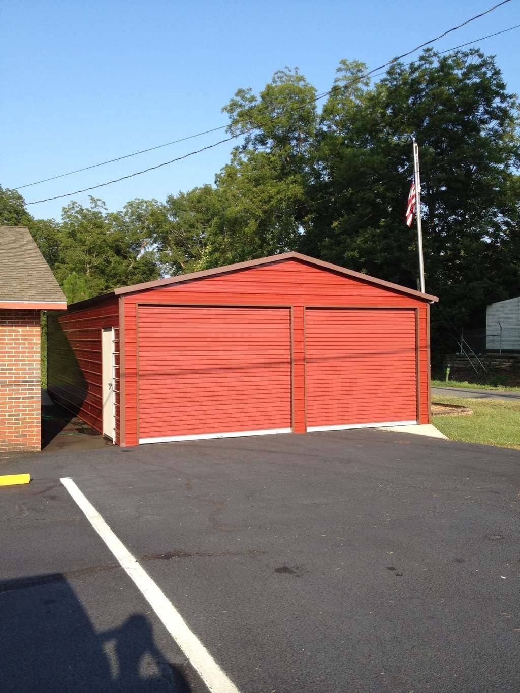 A red garage with a flag in the background