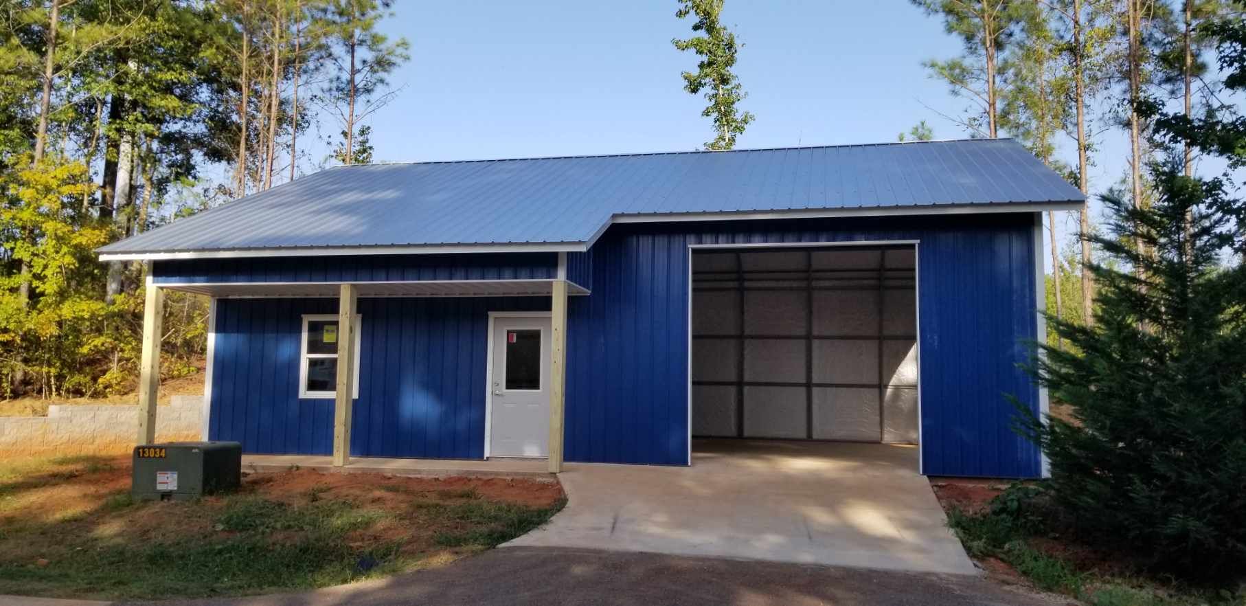 A blue garage with a porch and a garage door.