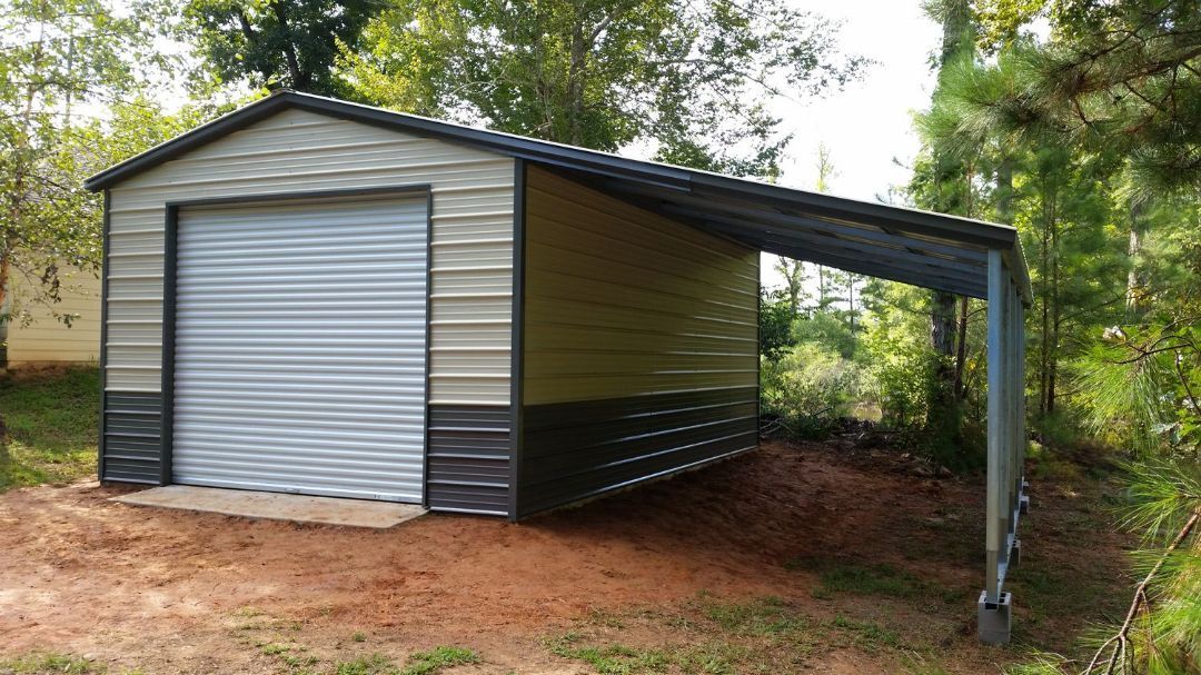A metal garage with a carport attached to it.