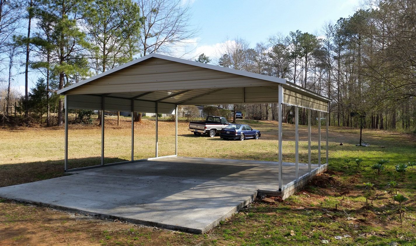 A carport with a truck parked underneath it in a field.