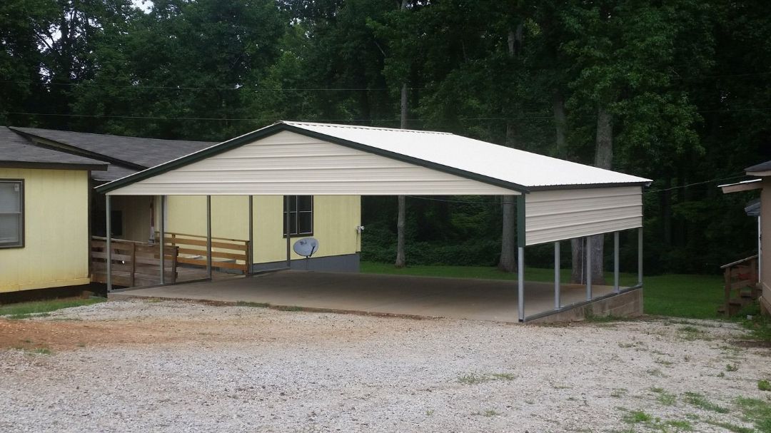 A carport is sitting in front of a yellow house.