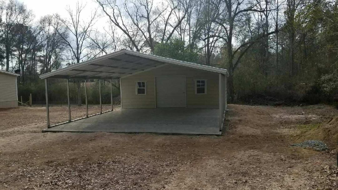 There is a carport in the backyard of a house.