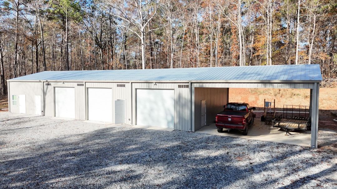 A red truck is parked under a canopy in a garage.