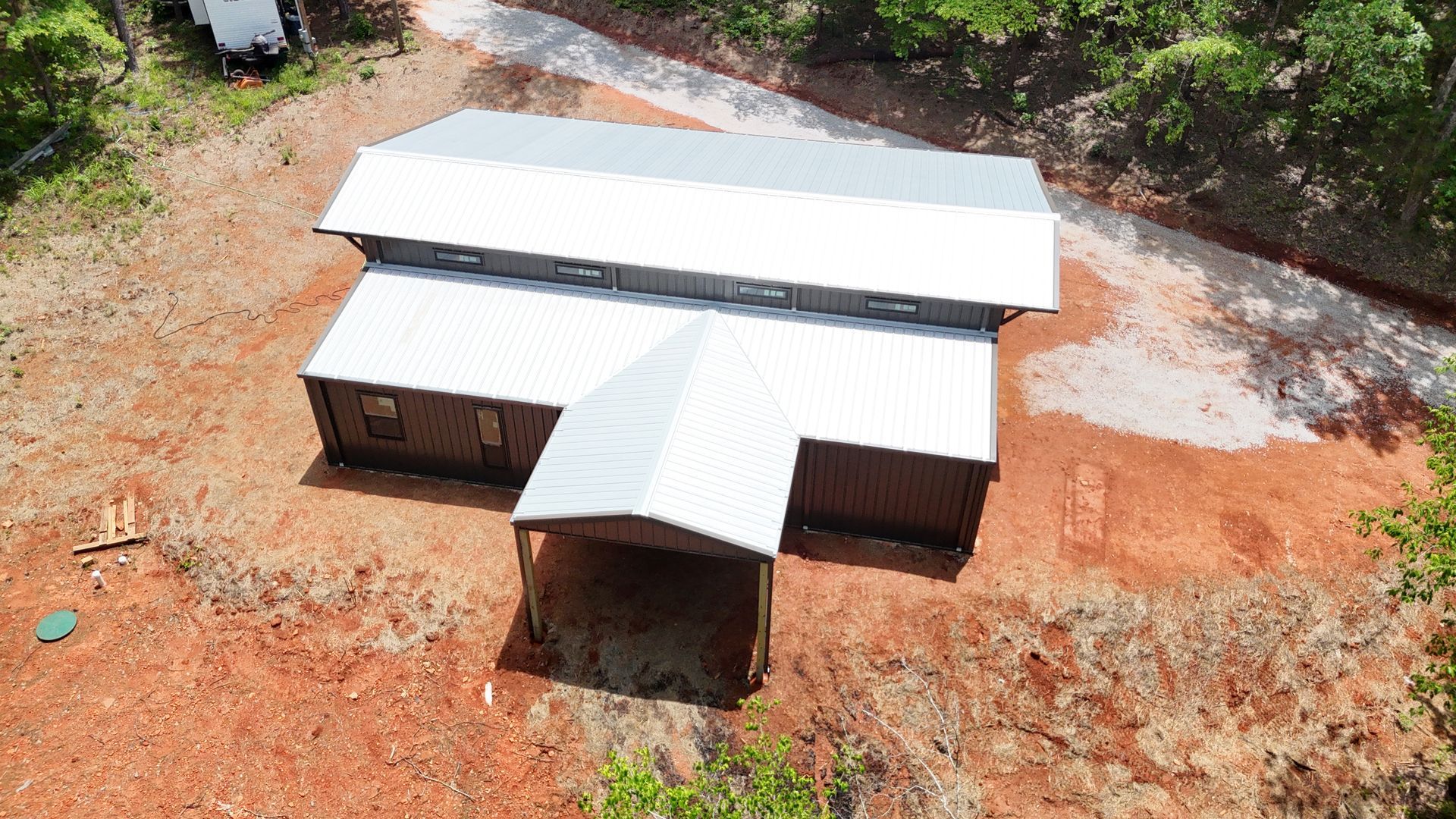 An aerial view of a house in the middle of a dirt field.