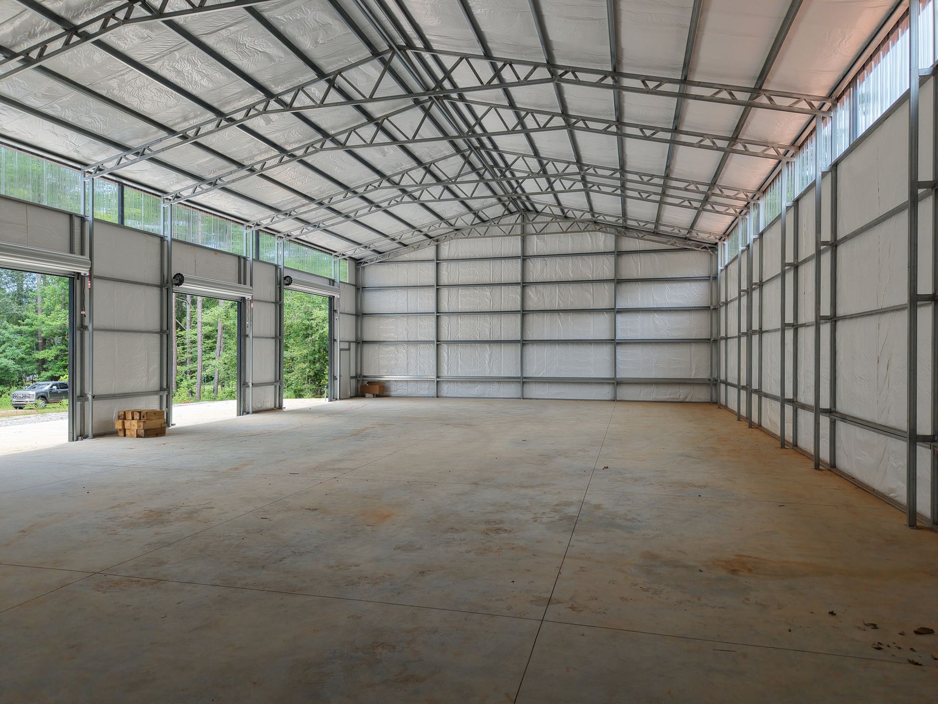 A large empty warehouse with a lot of windows and doors.