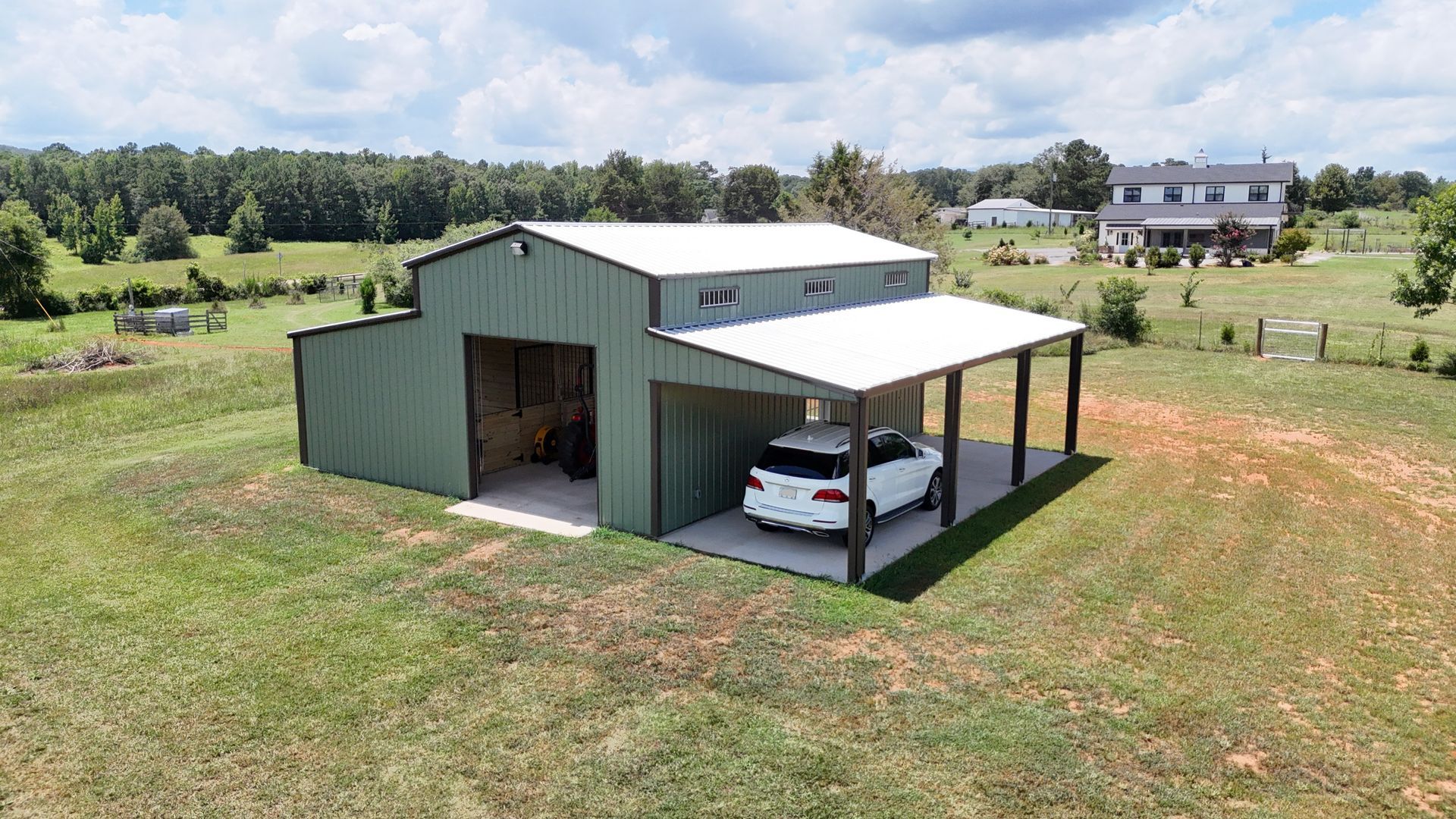 A car is parked in a garage under a covered porch.