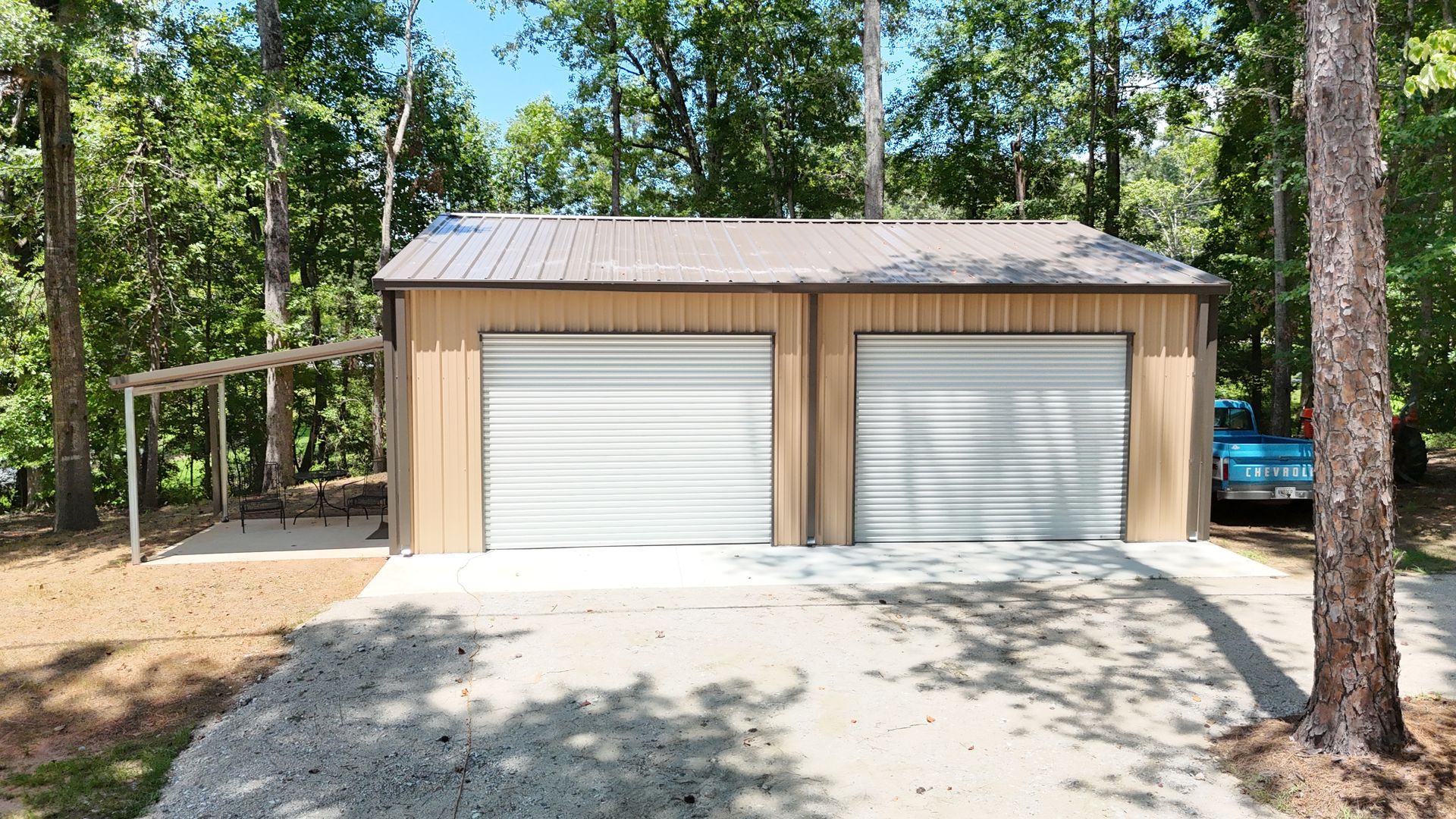 A garage with two garage doors and a car parked in front of it.