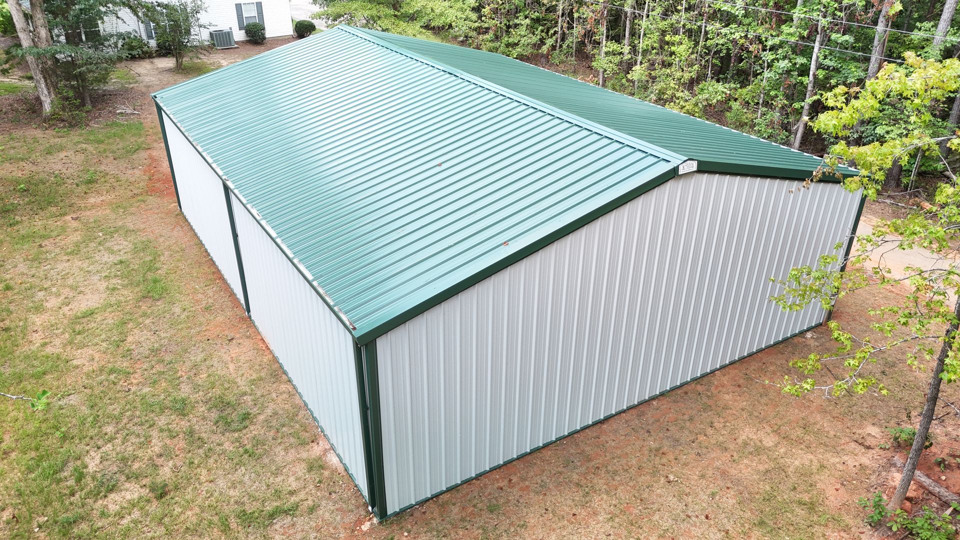 An aerial view of a metal building with a green roof.