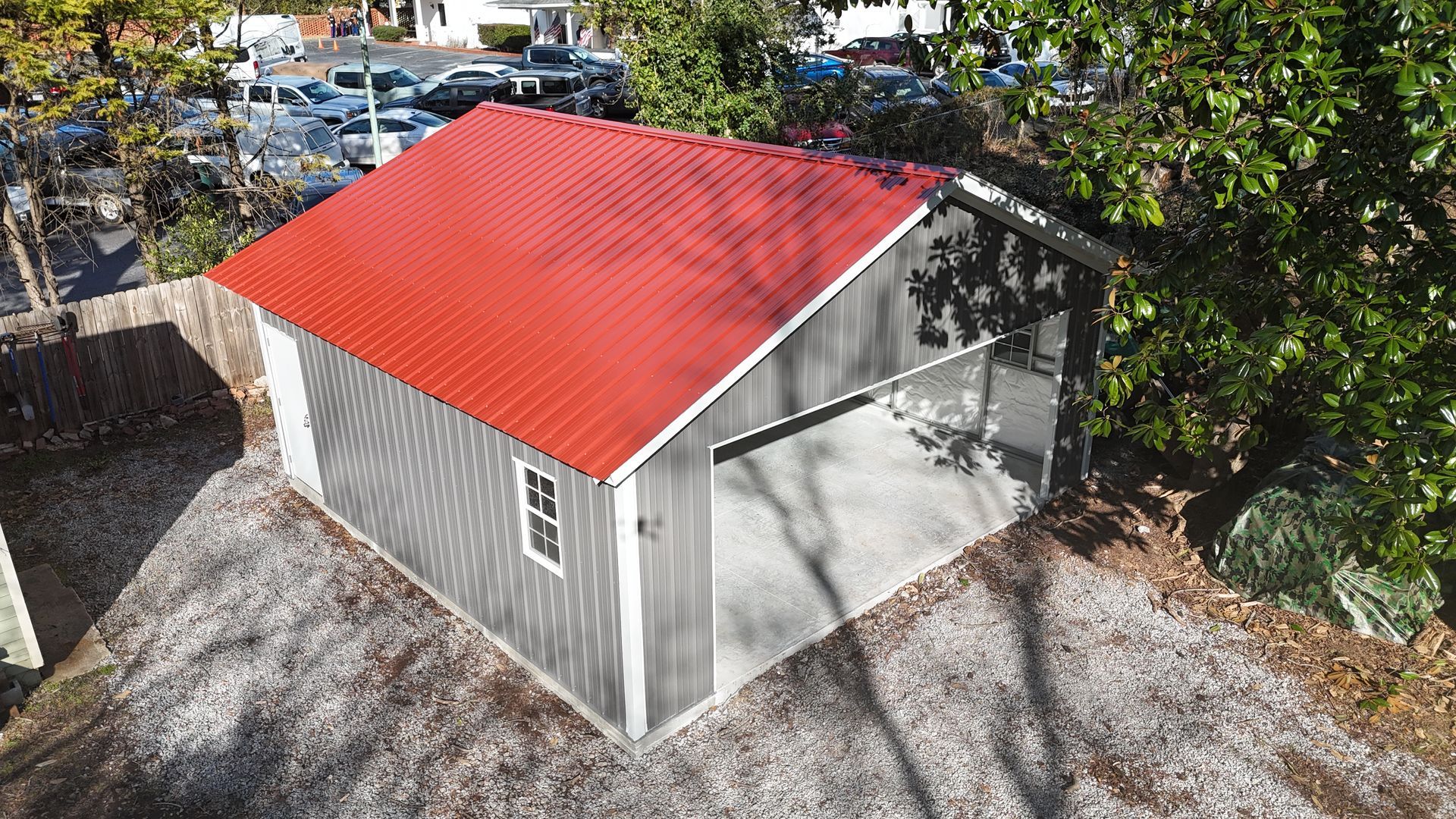 Gray shed with red roof and open bay.