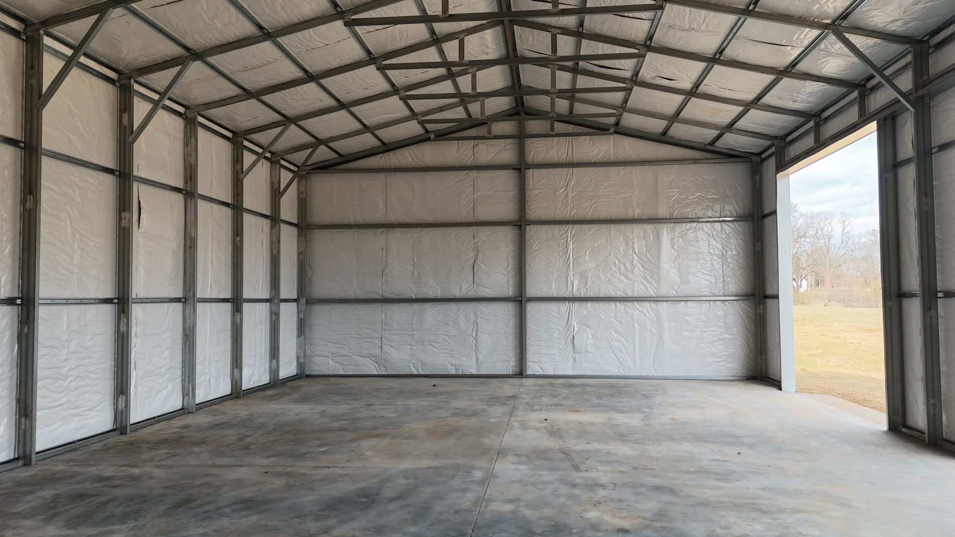 Interior of a metal building with spray foam insulation on the walls and ceiling.
