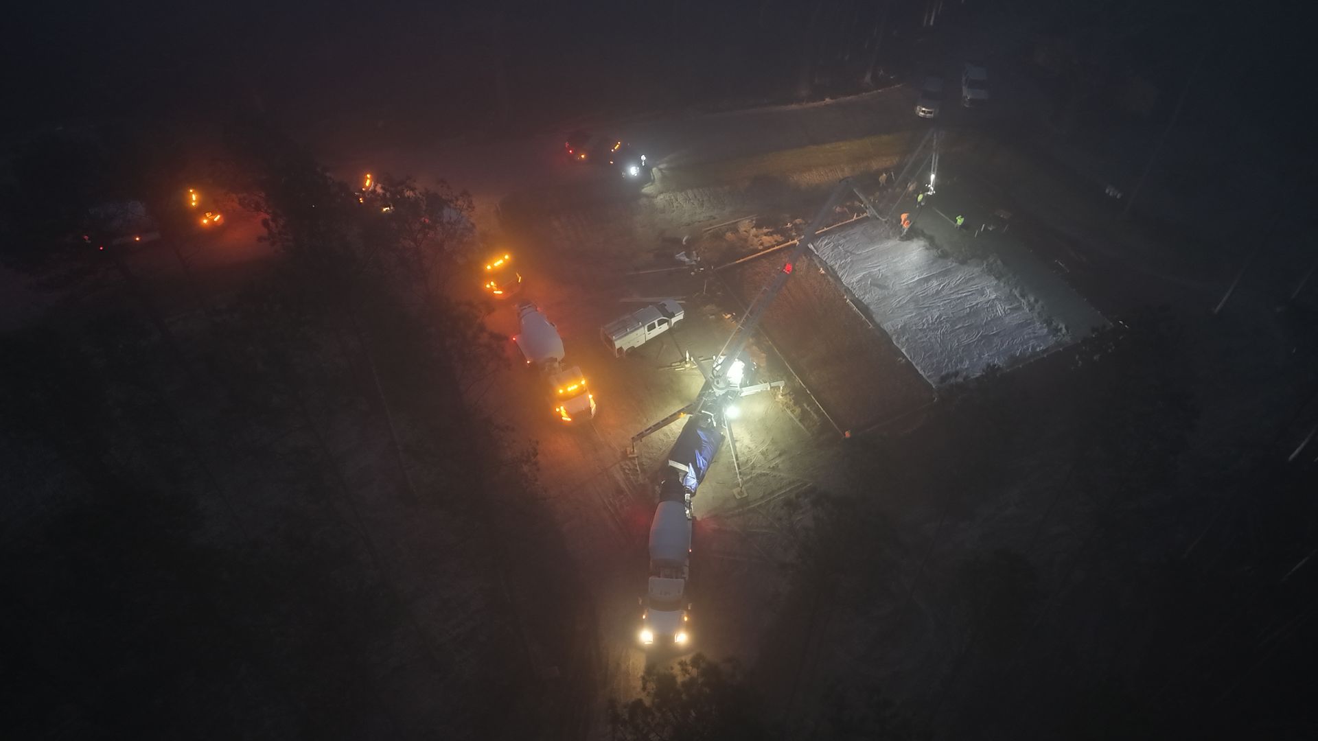 Overhead nighttime view of vehicles with lights at an incident scene.