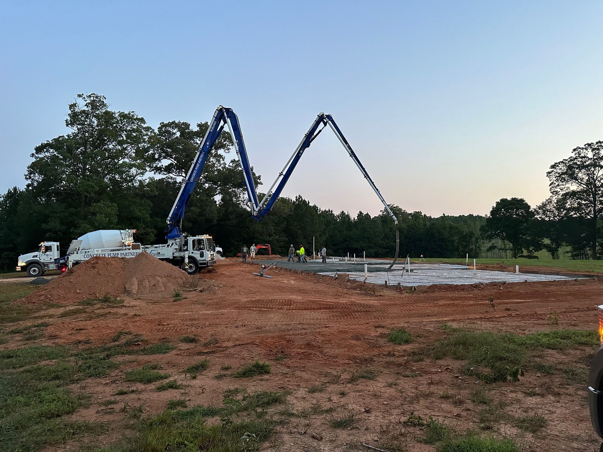 A concrete pump is being used to pour concrete on a construction site.