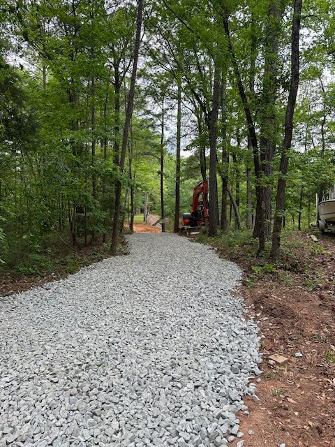 A gravel driveway in the middle of a forest.