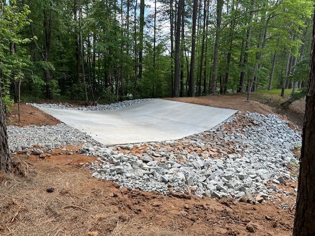 A large concrete slab is sitting on top of a pile of rocks in the middle of a forest.