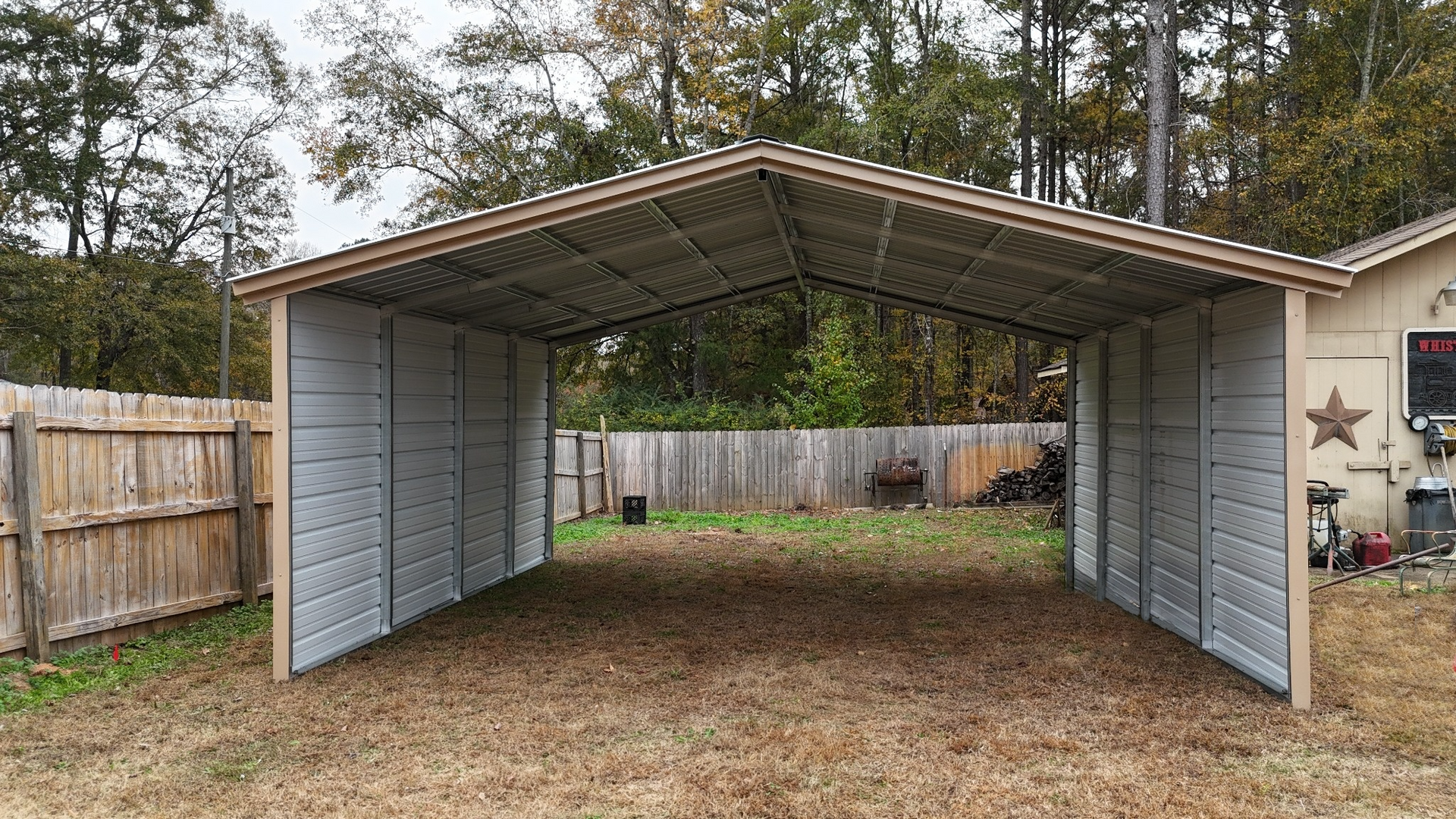 Carport with gray walls and roof, tan trim, open to a backyard.