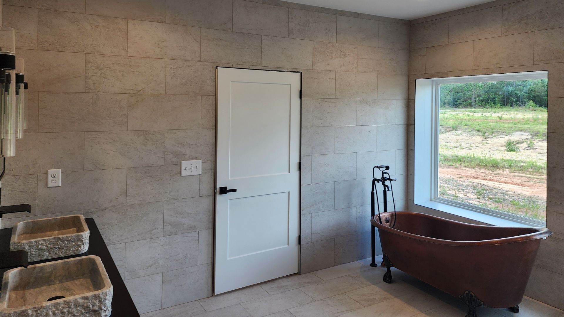 A bathroom with a tub , sinks and a window.