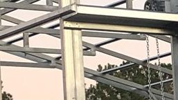 A close up of a metal structure with chains hanging from it.