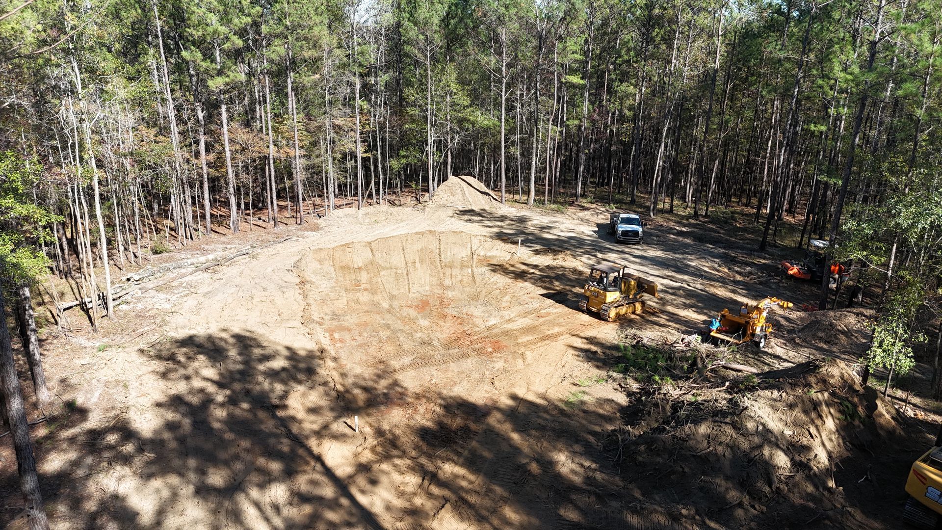 An aerial view of a construction site in the middle of a forest.
