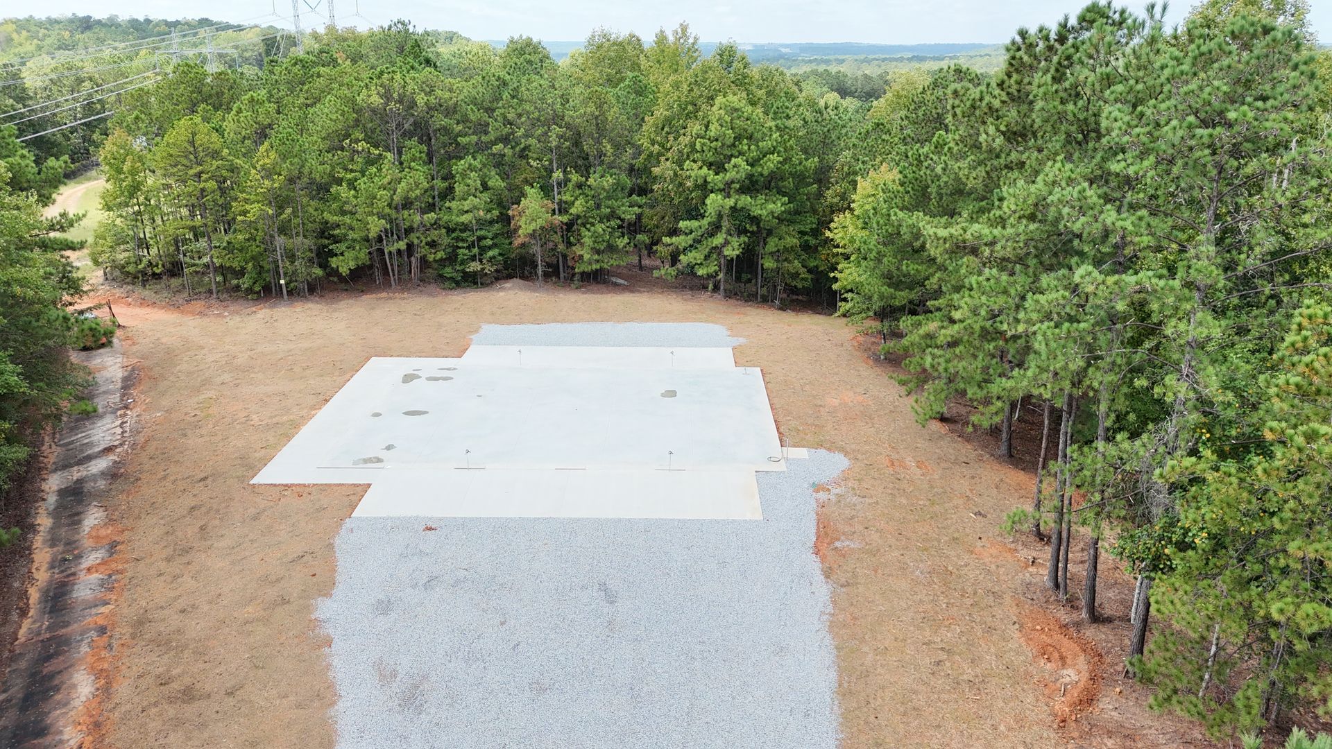 An aerial view of a gravel road surrounded by trees.