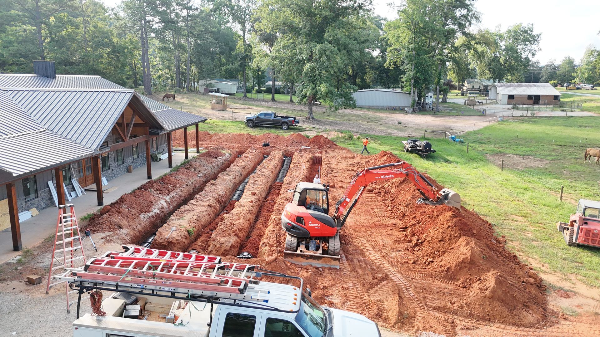 A large pile of dirt is sitting in front of a house under construction.