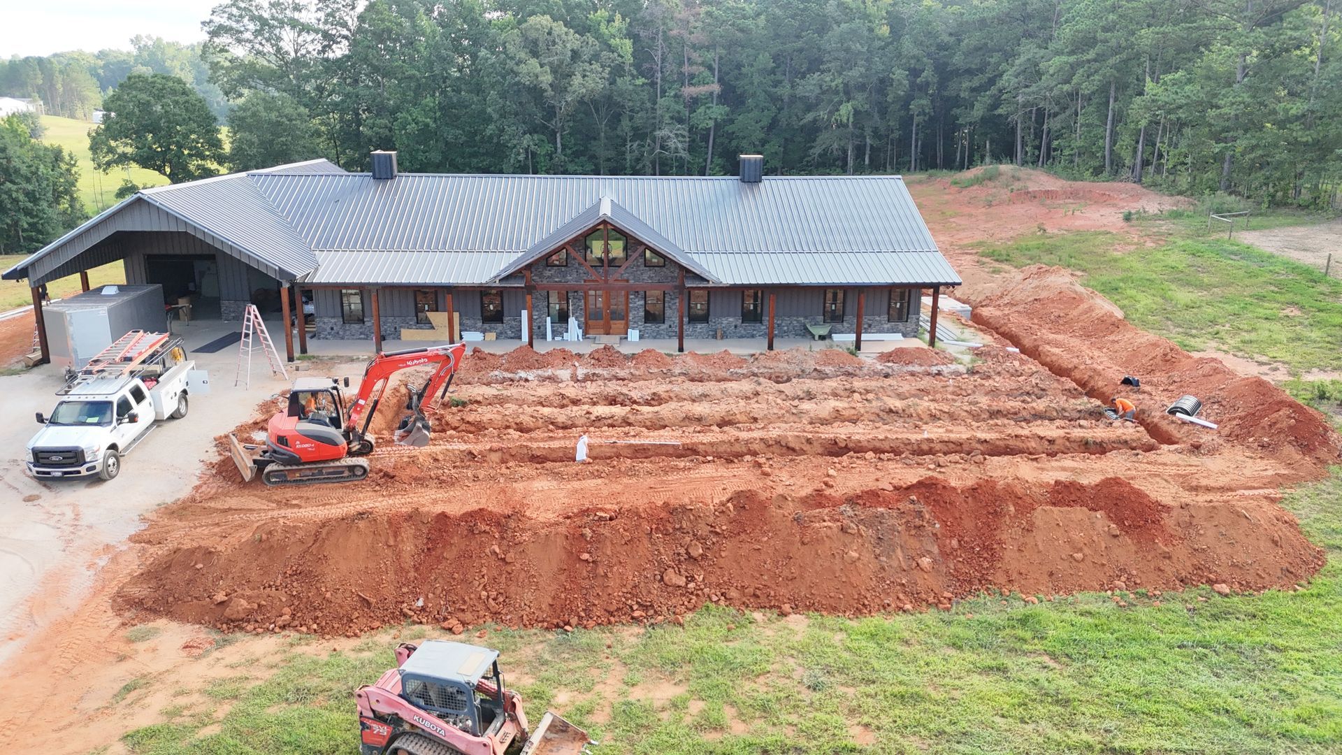 An aerial view of a house under construction with a lot of dirt in front of it.