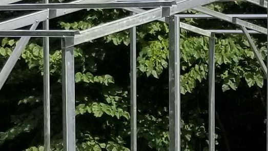 A close up of a metal structure with trees in the background.