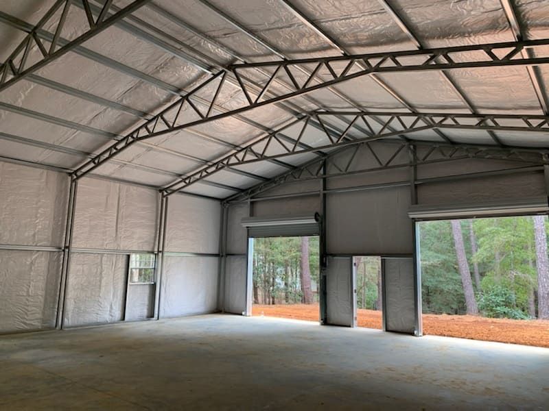 The inside of a large metal building with a large garage door.