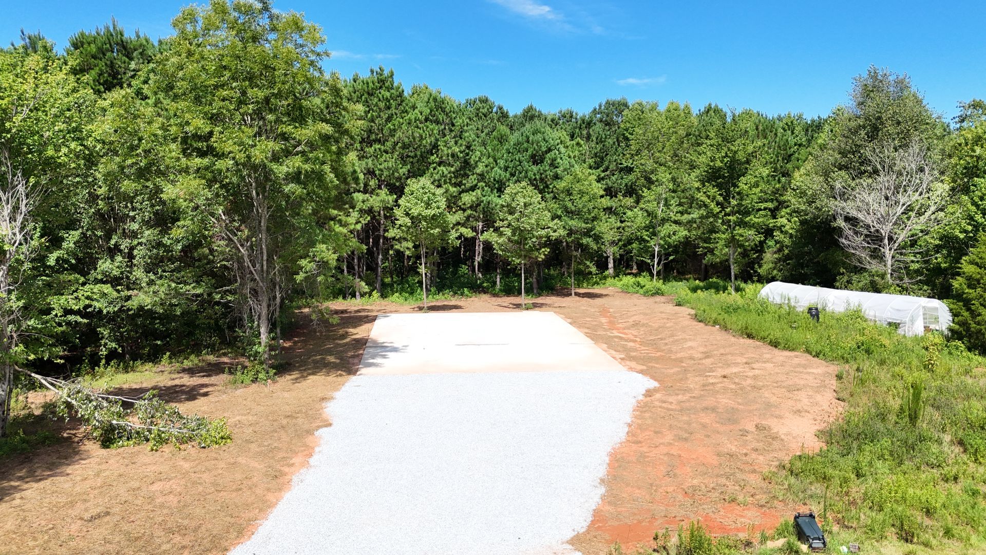 An aerial view of a dirt road in the middle of a forest.