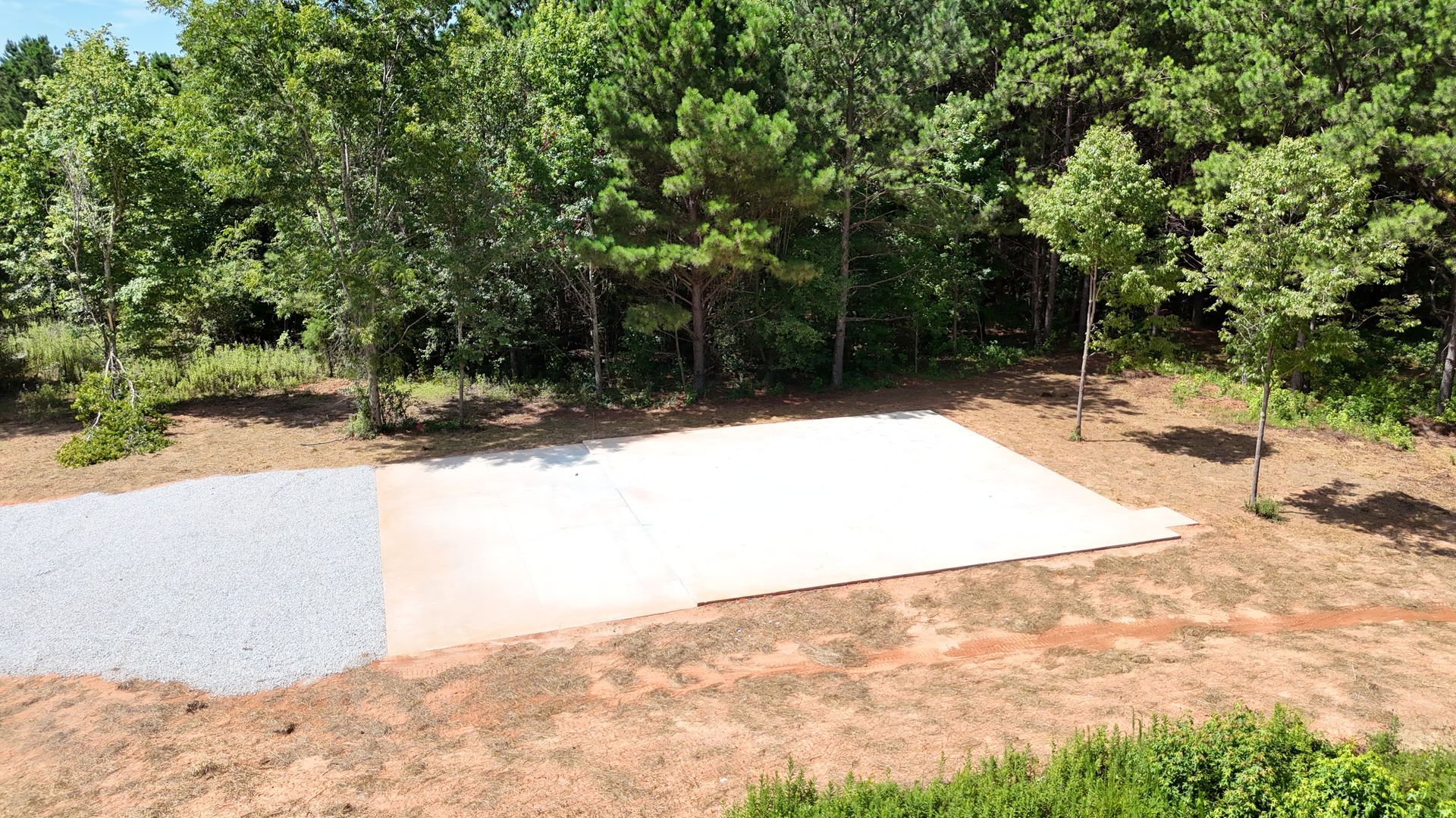 A large white sheet of paper is sitting in the middle of a field surrounded by trees.