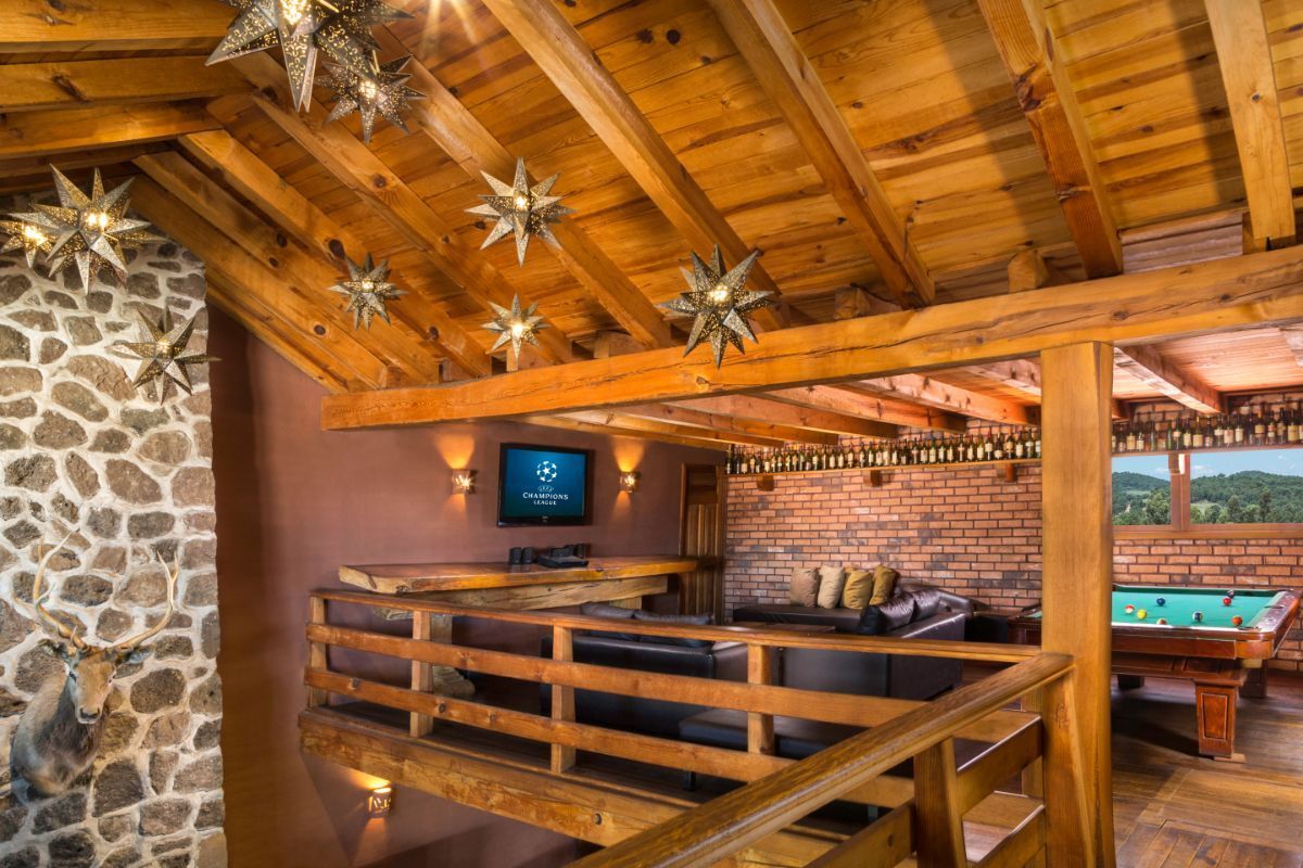 A living room with a wooden ceiling and a pool table