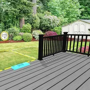 Wooden deck overlooking a green backyard with a white shed and landscaped shrubs.