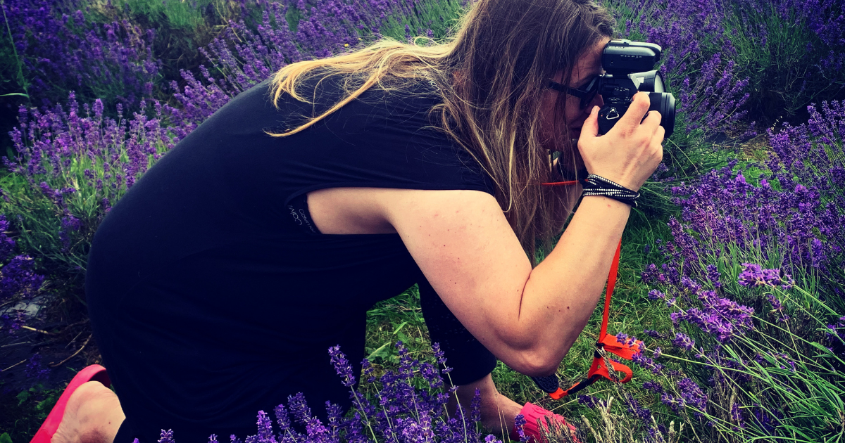 Fine art photographer Oana Baković photographing wildflowers outdoors.