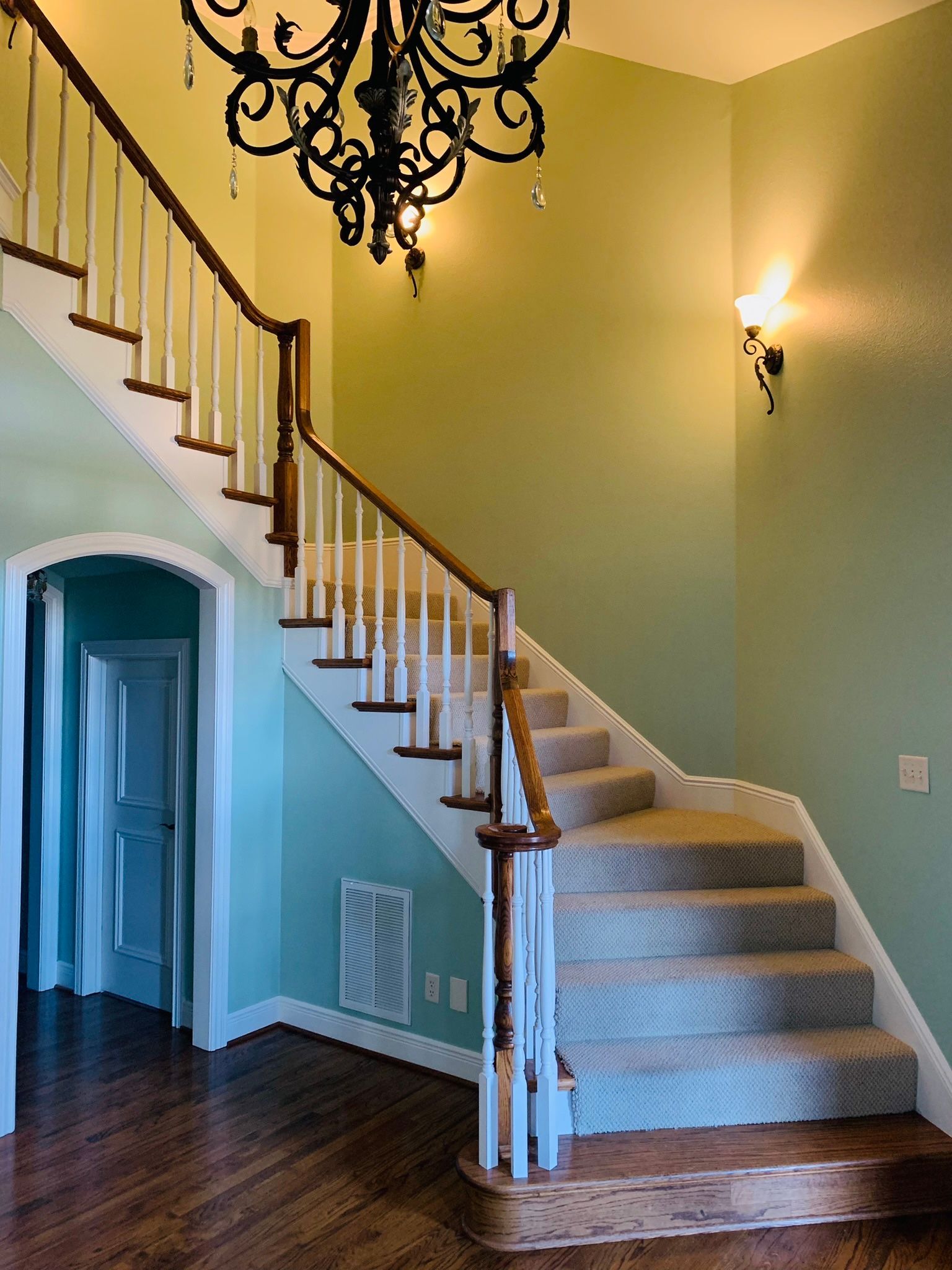A staircase with a chandelier hanging from the ceiling