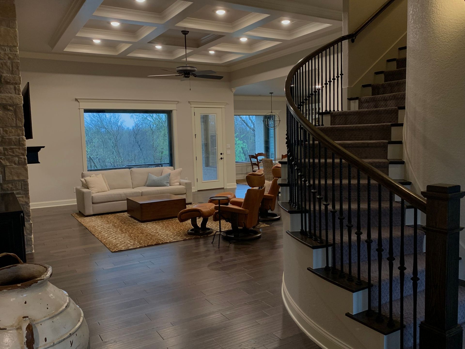 A living room with a couch , chairs , and stairs.