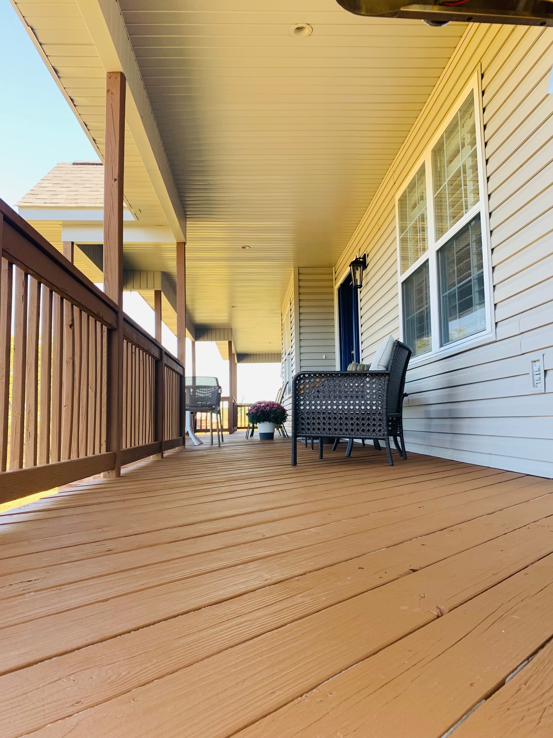 A wooden deck with a railing overlooking the ocean