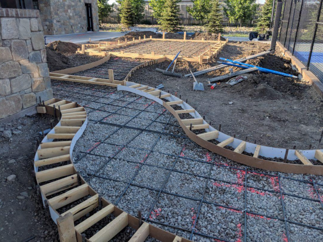“Curved concrete driveway form with gravel base and rebar prepared for pouring by a concrete contractor in Casas Adobes, AZ”