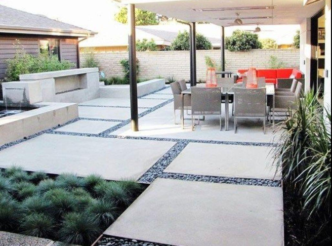 “Covered outdoor patio with clean concrete slabs, gravel accents, and dining space by a concrete contractor in Casas Adobes, AZ”