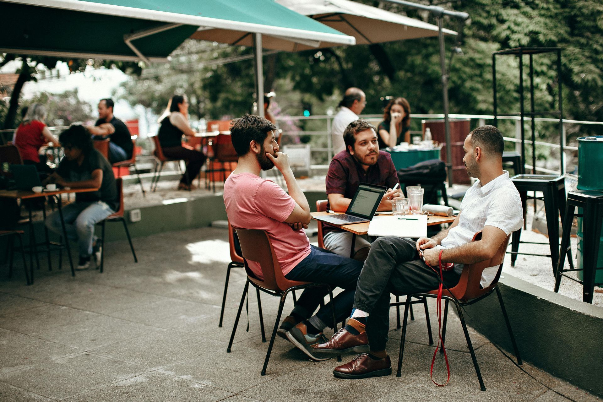 A group of men are sitting at a table in a restaurant for a business meeting.