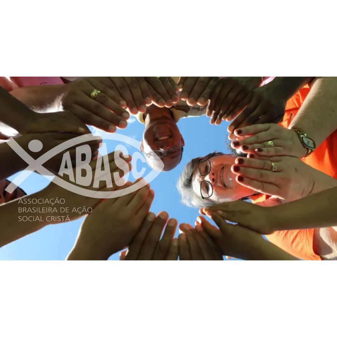 Um grupo de pessoas de mãos dadas em um círculo com o logotipo da aba sc ao fundo