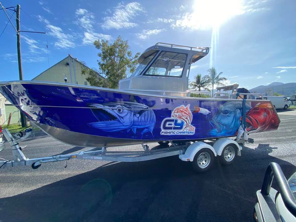 A boat is sitting on a trailer in a parking lot.
