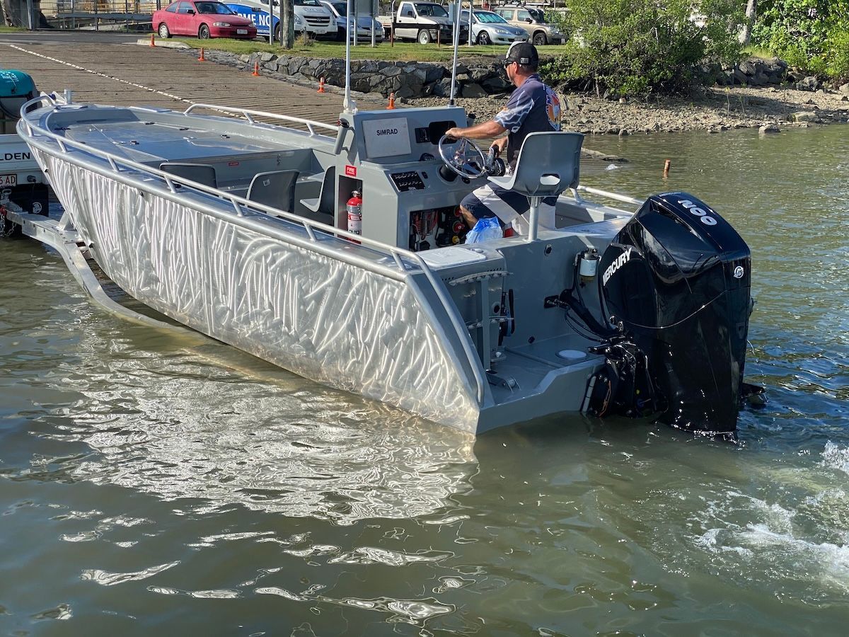 A man is driving a boat in the water.