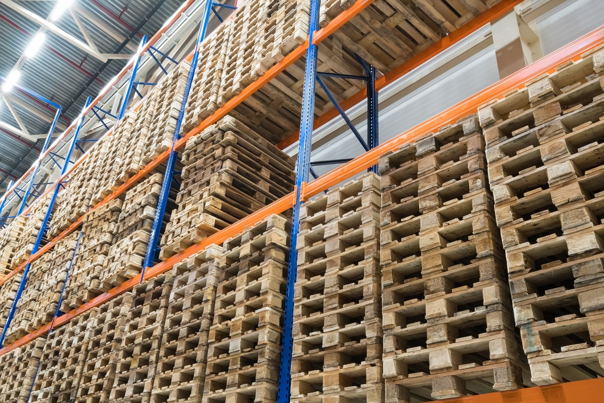 A warehouse filled with lots of wooden pallets on shelves