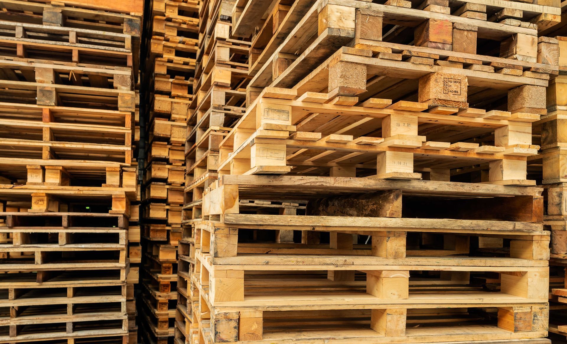 A pile of wooden pallets stacked on top of each other in a warehouse