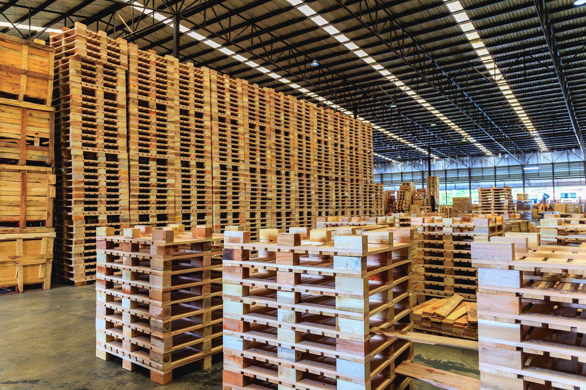 A warehouse filled with lots of wooden pallets stacked on top of each other
