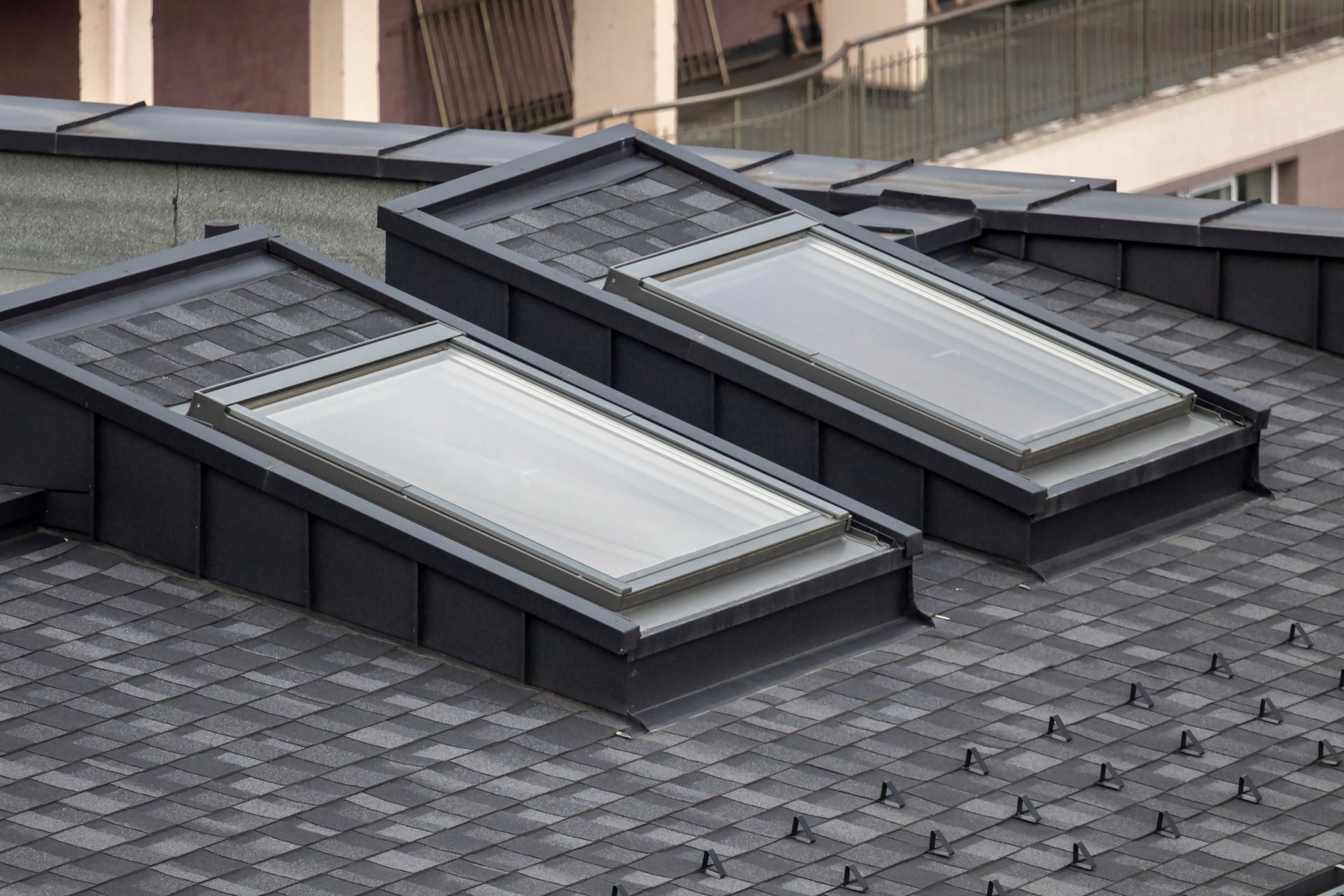 Three rooftop skylights on a gray shingled roof, seen from above